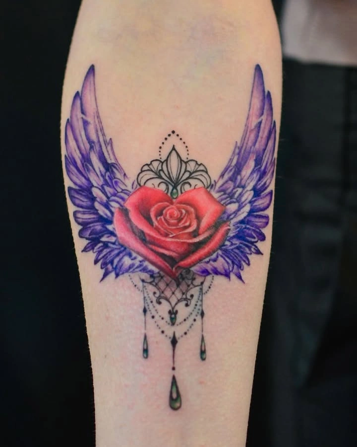 Tatuaj colorat cu trandafir roșu și aripi violet pe braț