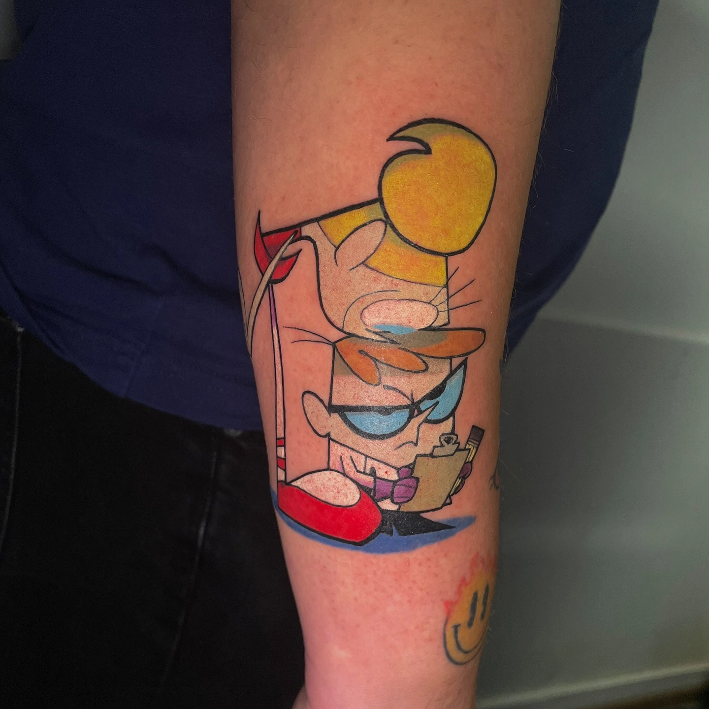 Tatuaj cu un personaj animat pe brațul unei persoane în culori vibrante