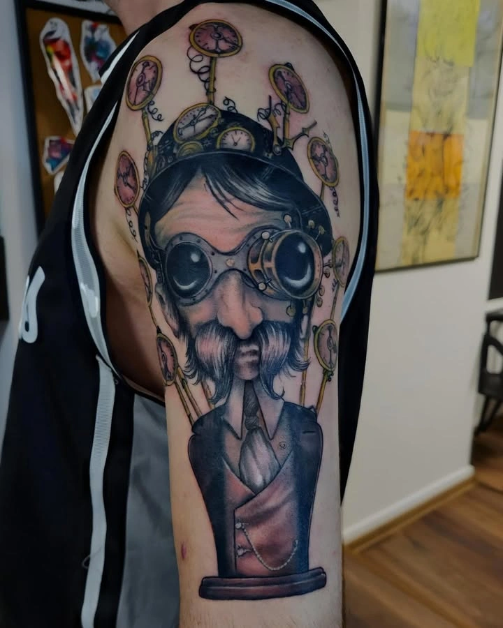 Tatuaj detaliat pe braț cu portret steampunk și ceasuri
