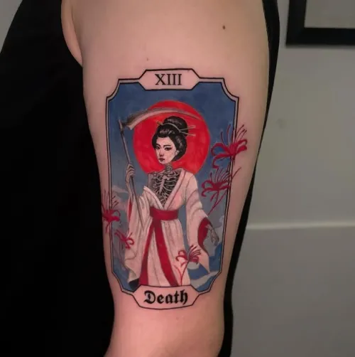 Tatuaj color pe braț reprezentând cartea de tarot XIII Death, cu o figură feminină stilizată în kimono, elemente scheletice, soare roșu și flori decorative.