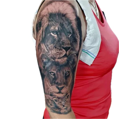 Tatuaj realist cu un leu, o leoaică și pui pe brațul unei persoane